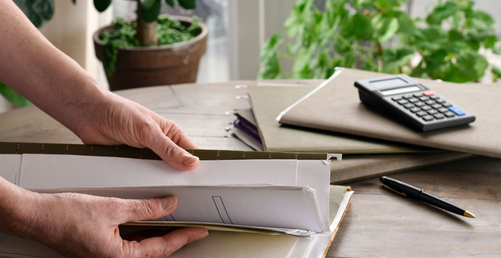 Dossier de permis de construire ouvert sur un bureau avec plans et formulaire.